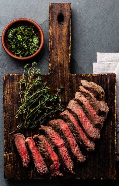 istock Mediun rare beef steak on wooden board. Top view 698211238