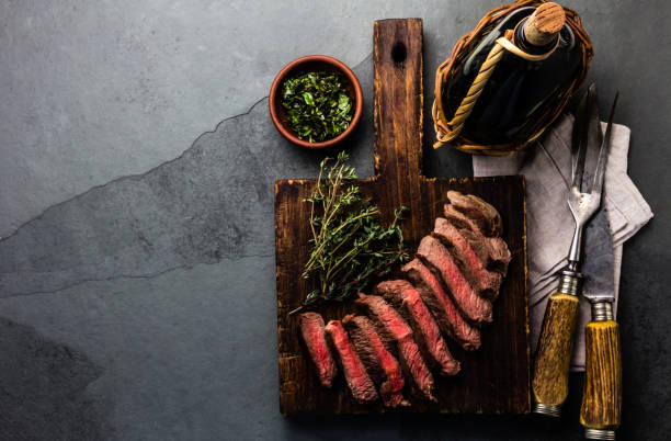 スレートの背景にワインとミディアムレアの牛肉ステーキ - sirloin steak 写真 ストックフォトと画像