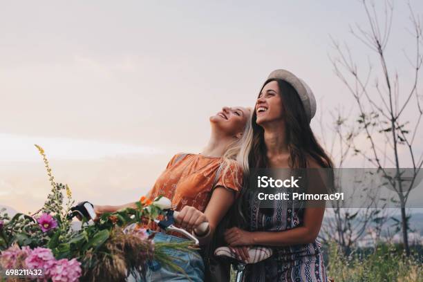 Two Girls Enjoy Bike And Great Day Stock Photo - Download Image Now - Springtime, Friendship, Female Friendship