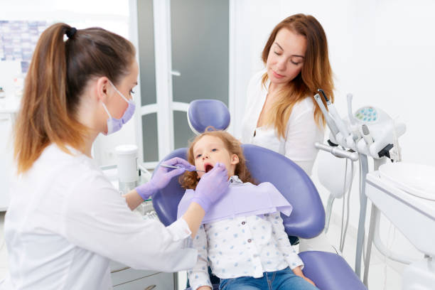 istock Dentists examining little girl 698212128