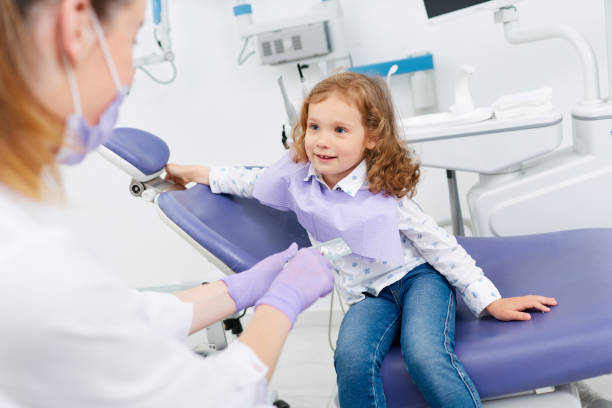 istock Smiling girl visiting dentist 698217200