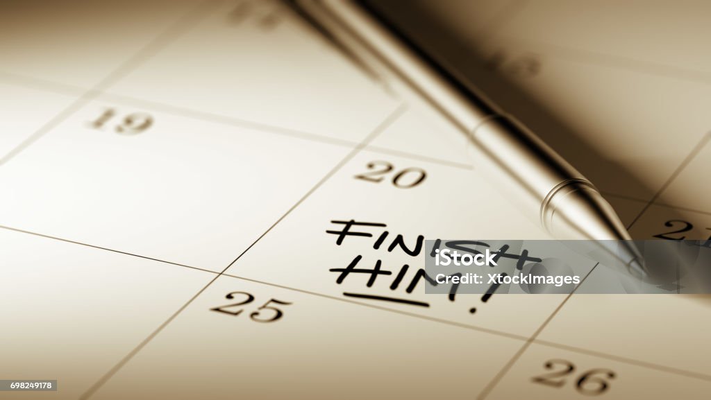 Calendar Concept Closeup of a personal agenda setting an important date written with pen. The words Finish Him written on a white notebook to remind you an important appointment. Calendar Stock Photo