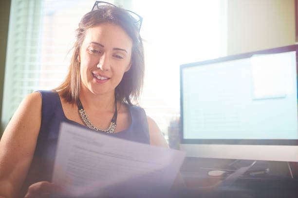 istock Happy Businesswoman reading through paperwork 698258432