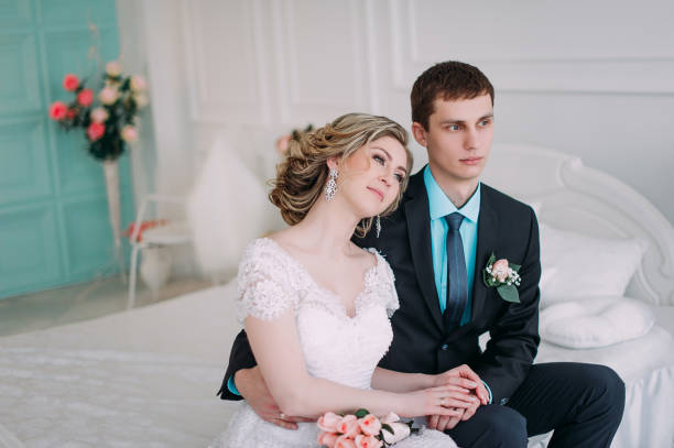 szczęśliwa para. ślubna sesja zdjęciowa w białym studio z pocałunkami wystroju ślubnym, uściskami - couple indoors studio shot horizontal zdjęcia i obrazy z banku zdjęć