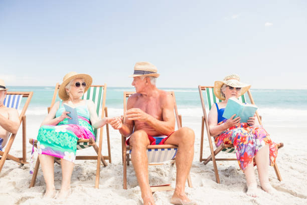 istock Senior friends reading books on beach chairs 698265594