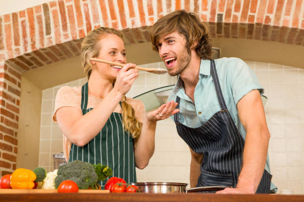 istock Pretty blonde making her boyfriend taste the preparation 698272704