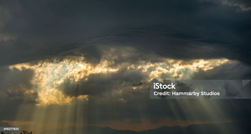 Low angle view of storm clouds on the sky with sumbeams Low angle view of storm clouds on the sky with sumbeams.  Horizontal composition. Image taken with Nikon D800 and developed from Raw format. Nimbostratus Stock Photo