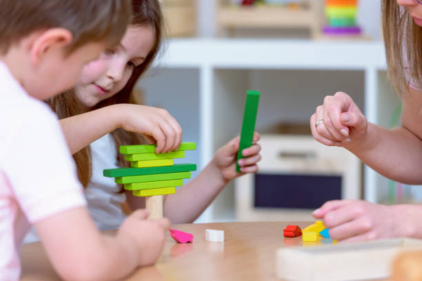 istock Preschool children with teacher in the classroom playing 698289846