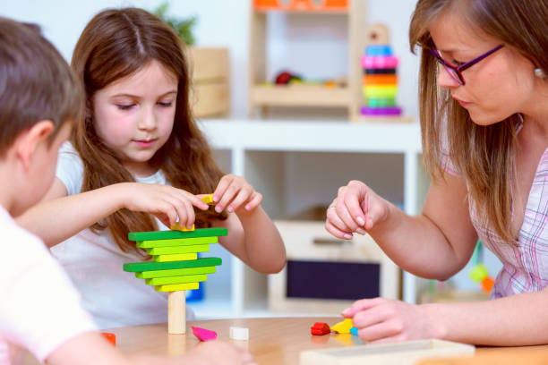 istock Preschool children with teacher in the classroom playing 698290312