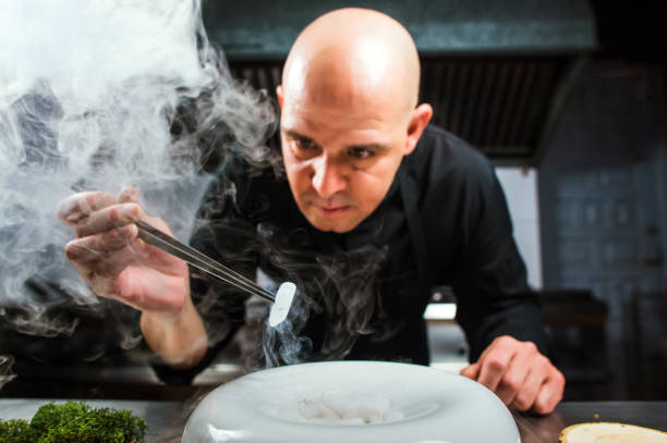 istock Chef is concentrated on preparing modern molecular dish with pincers and liquid nitrogen 698303270