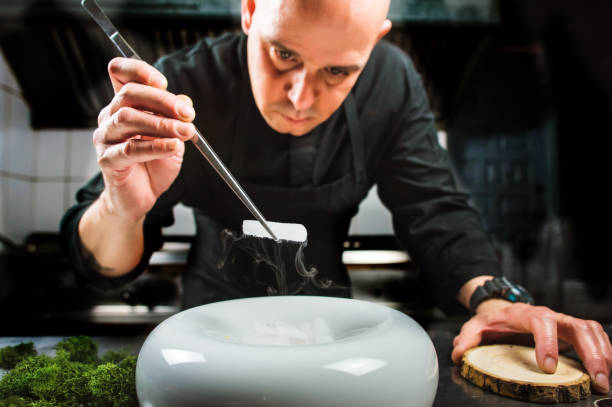 istock Chef is concentrated on preparing modern molecular dish with pincers and liquid nitrogen 698303822