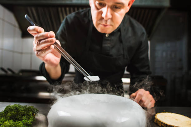 istock Chef is concentrated on preparing modern molecular dish with pincers and liquid nitrogen 698314324