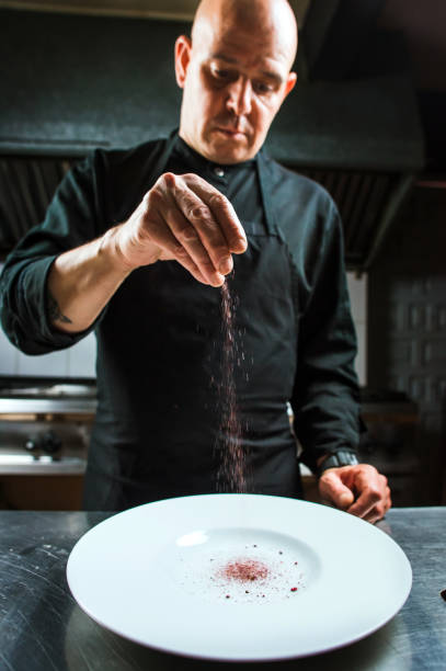 istock Young bold male chef flavouring molecular dish 698316016