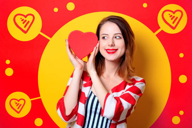 istock Woman with heart shape box on yellow background 698326526
