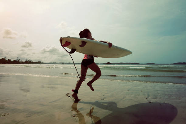 istock Young woman surfer wit surfboard ready to surf 698326980