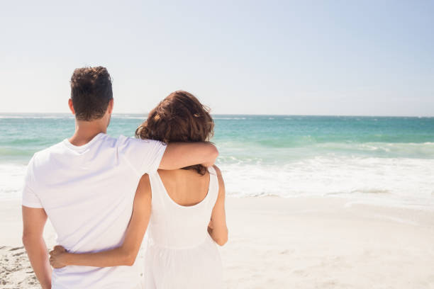 istock Young couple looking at the beach 698343814