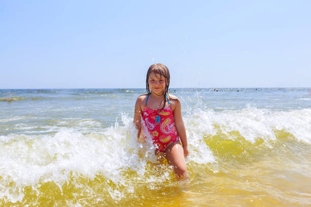 istock happy girl on a tropical beach ocean has fun with splash 698344800
