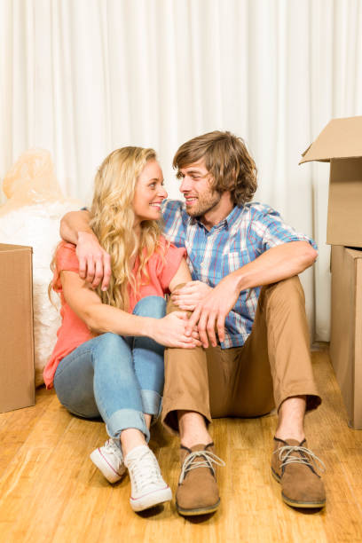 istock Happy couple sitting on the floor 698355946