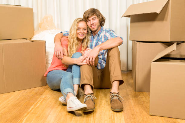 istock Happy couple sitting on the floor 698355988