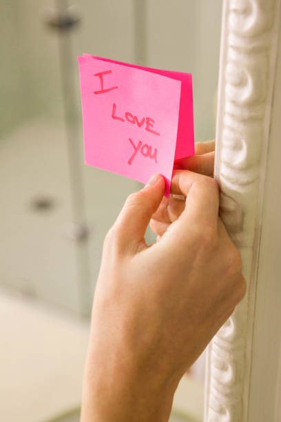 istock Woman sticking I love you note on mirror 698356950