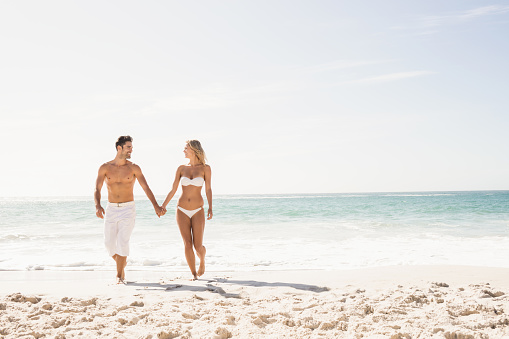 Young couple holding hands on the beach