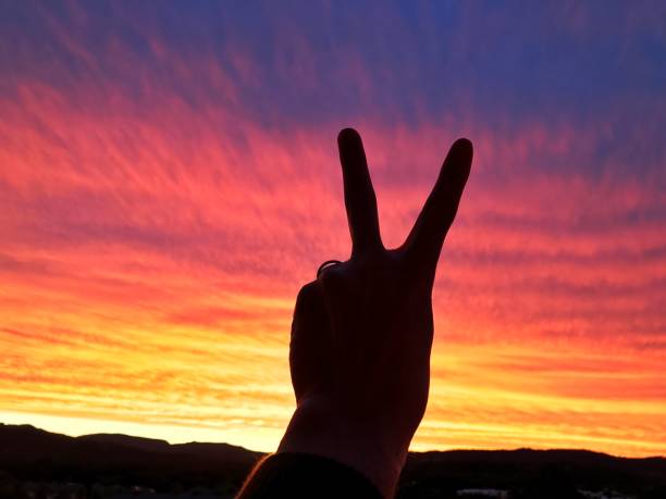 istock A vibrant sunset overlooking mountains with a peace sign 698396584