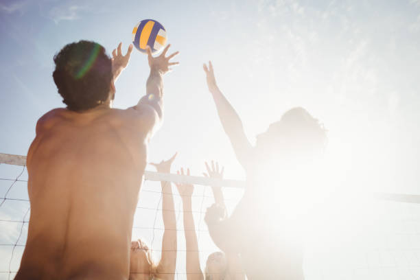 amici che giocano a beach volley - volleyball net leisure activity beach foto e immagini stock