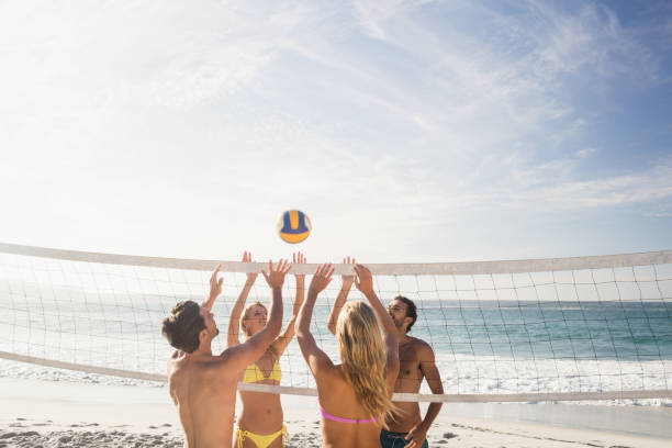 istock Happy friends playing beach volleyball 698421022