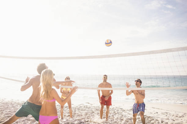 istock Happy friends playing beach volleyball 698421690