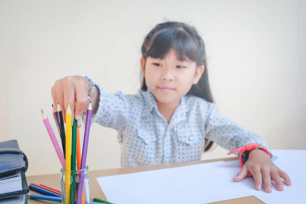istock Happy school children drawing with crayons 698425872