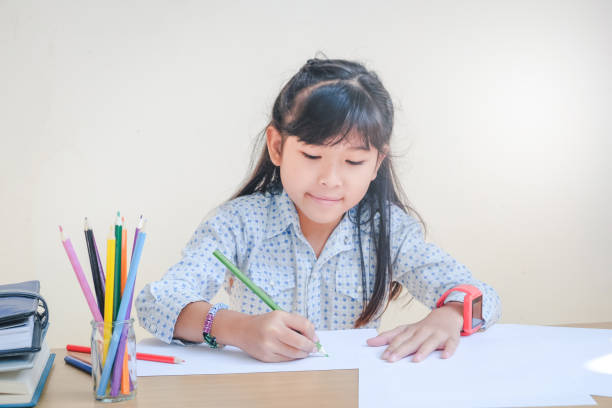 istock Happy school children drawing with crayons 698426360