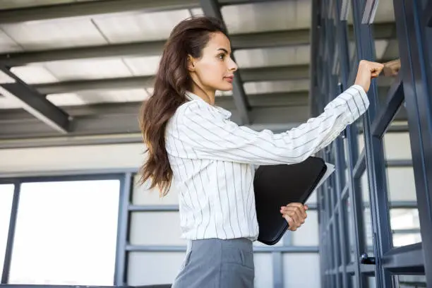 Businesswoman knocking on door in office