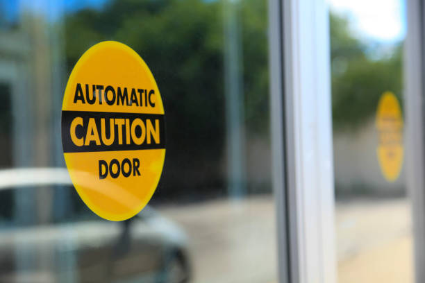 Automatic Door Caution Sign Automatic door caution stickers attached to a store glass doors. entrance sign photos stock pictures, royalty-free photos & images