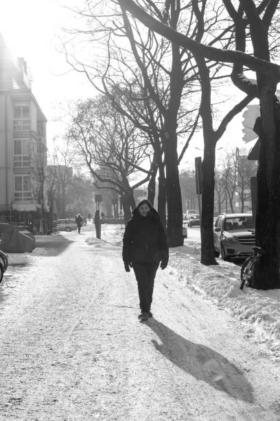 istock Woman Walks on the Sidewalk Snow in Winter 698442484