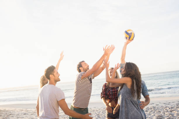 istock Happy friends playing beach volleyball 698475936