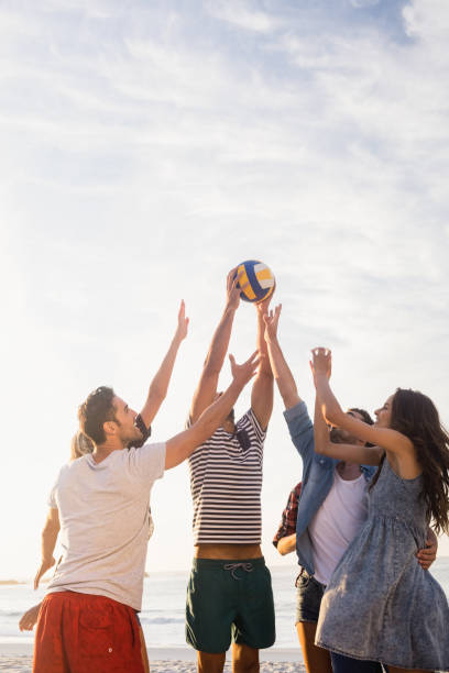 istock Happy friends playing beach volleyball 698475972