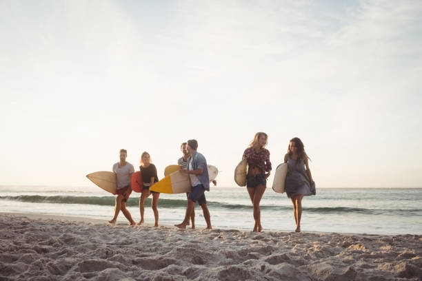 istock Happy friends walking with surfboards 698476182