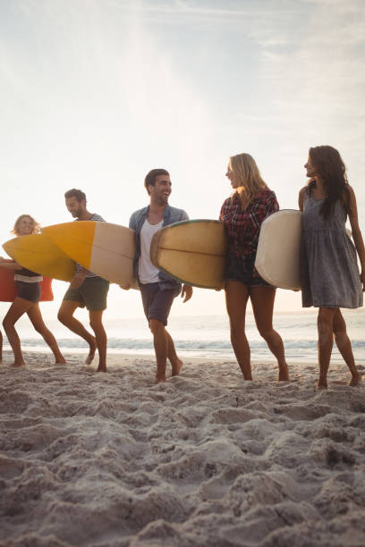 istock Happy friends walking with surfboards 698476248