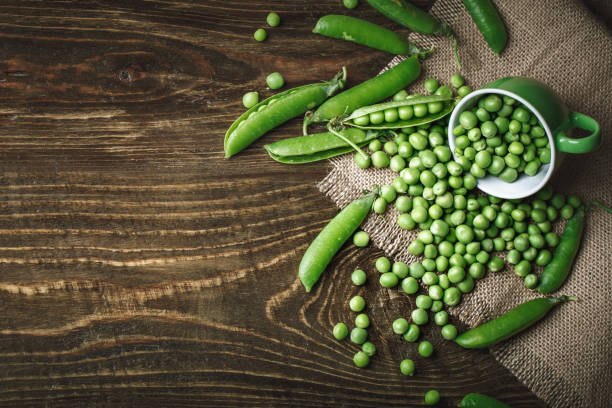 istock Delicious ripe green peas lying on a wooden table 698500486