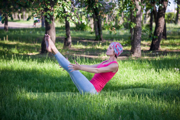 młoda kobieta robi jogę i gimnastykę w parku. pozy łodzi - human pregnancy physical activity women india zdjęcia i obrazy z banku zdjęć