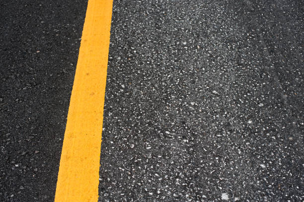 istock Close up asphalt surface of road divide yellow lines 698501646