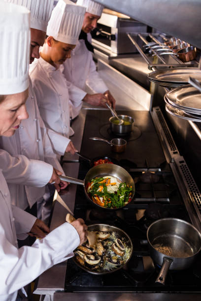 istock Group of chef preparing food in the kitchen 698504296