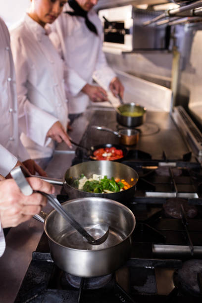 istock Group of chef preparing food in the kitchen 698507268