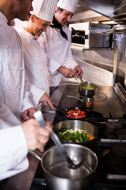 istock Group of chef preparing food in the kitchen 698507388