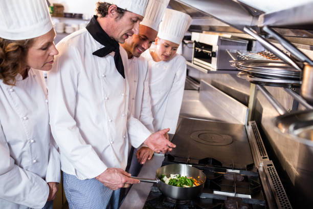 istock Experienced head chef explaining to his colleagues in the kitchen 698507454