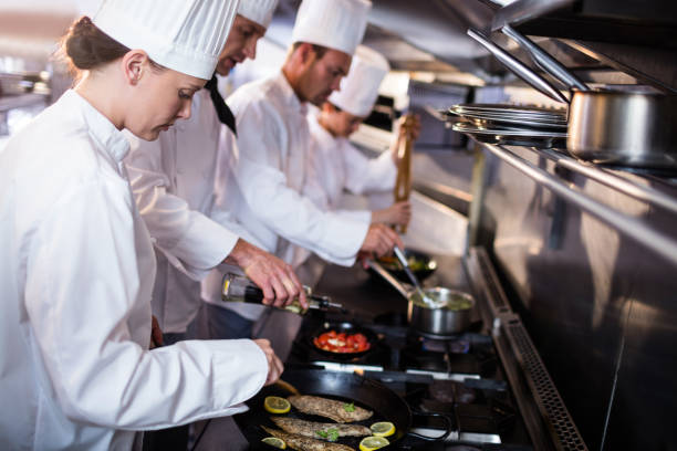 istock Chef frying fish in a frying pan 698508392