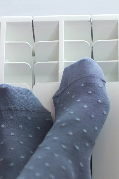 istock Wearing Socks and Heating Legs on Radiator 698511208
