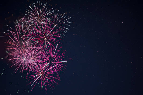 istock Maroon red pink celebration fireworks over night sky 698520408