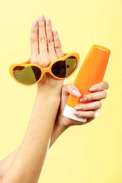 istock Woman holds sunglasses sunscreen lotion 698530544