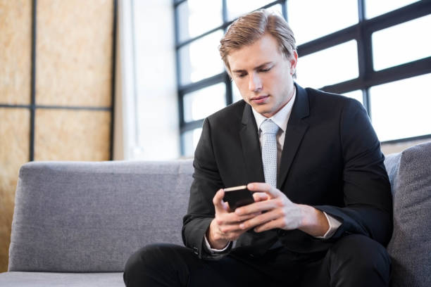 istock Businessman text messaging on mobile phone 698534568